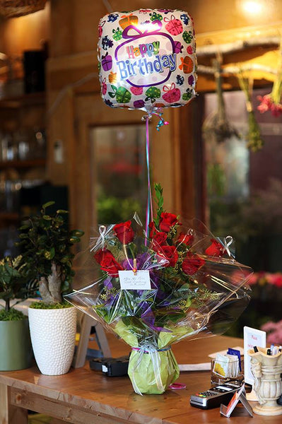 One dozen red roses in the vase with  mylar balloon